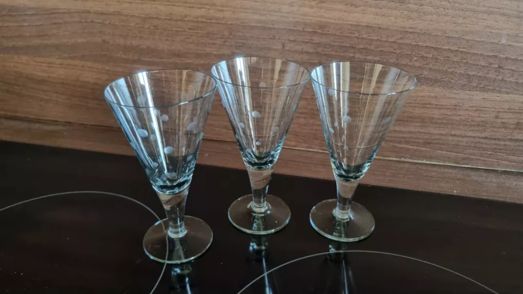 Dvi trikampės taškuotos taurelės ant kojelės